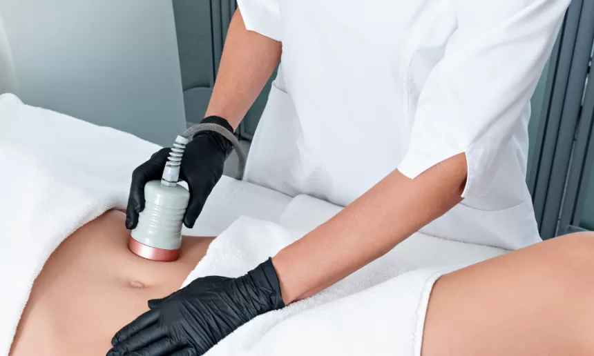 A woman undergoing laser treatment on her stomach as part of body contouring surgery for enhanced aesthetics.