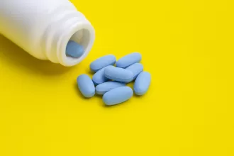 A healthcare professional explaining Doxycycline postexposure prophylaxis to a patient, showcasing a prescription pad and medication.