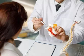 A doctor examines a human skeleton model, highlighting anatomy relevant to hiatal hernia surgery.