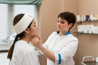 A woman consults with a doctor for a face examination following her laryngectomy procedure.