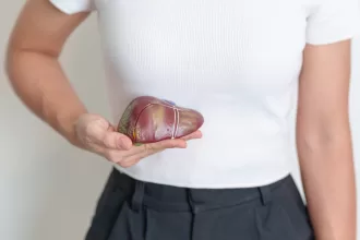 A woman holds a heart-shaped object, symbolizing hope and resilience in the context of liver resection recovery.