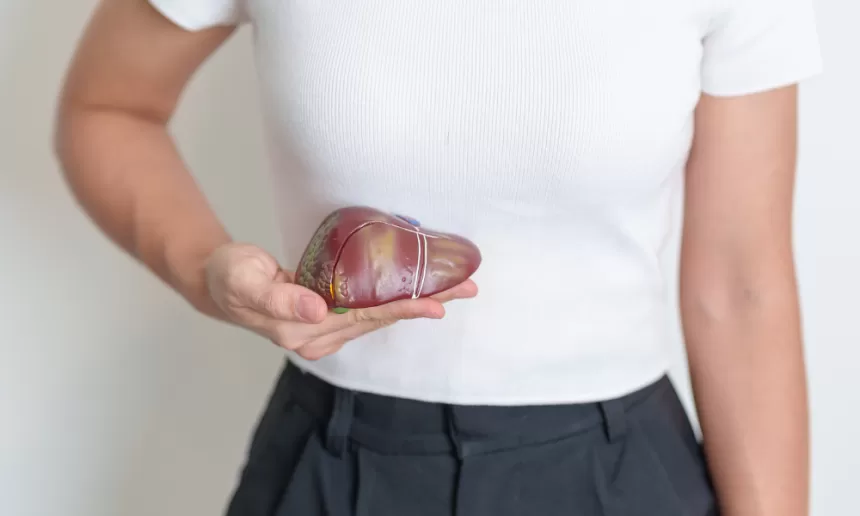 A woman holds a heart-shaped object, symbolizing hope and resilience in the context of liver resection recovery.