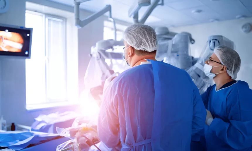 Two surgeons perform microsurgery on a patient in an operating room, focusing on nerve repair techniques.