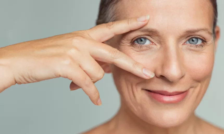 A woman with blue eyes and a bright smile, showcasing her recovery after orbital fracture repair surgery.