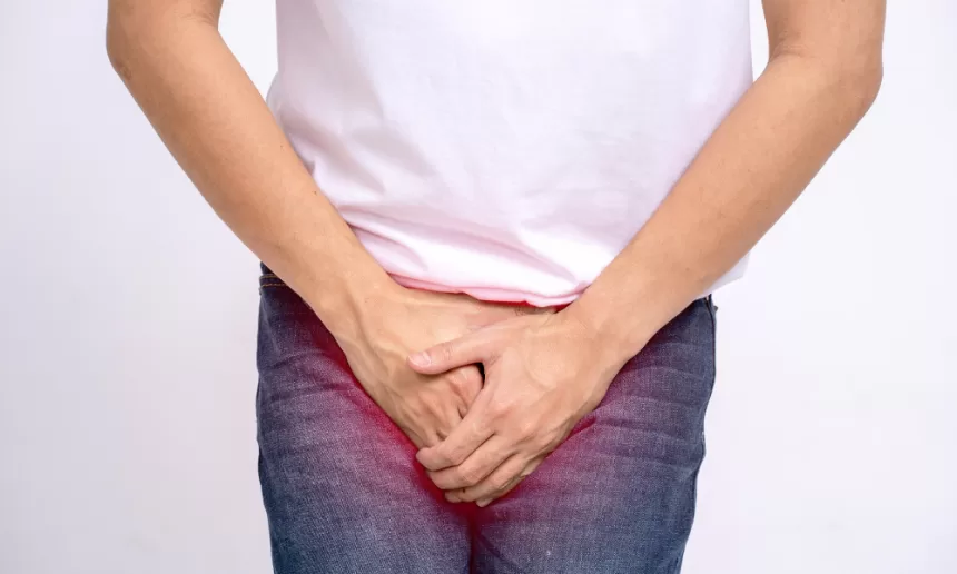 A man grimaces in discomfort, holding his stomach, reflecting the pain after prostate cancer surgery.