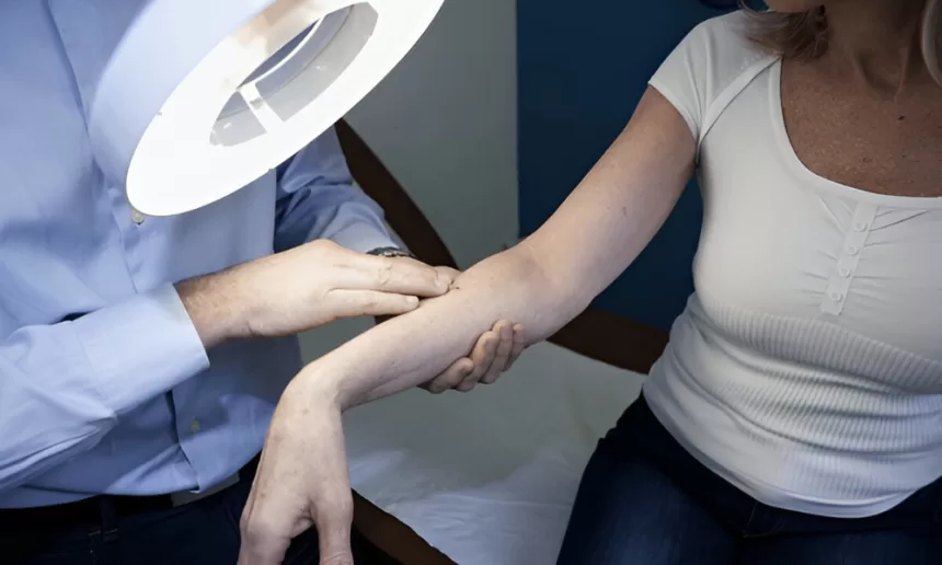 A woman receives an arm examination from a doctor, focusing on skin health related to Mohs surgery for skin cancer.