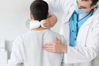 A doctor examines a man's neck, focusing on his health post-total hip replacement surgery.