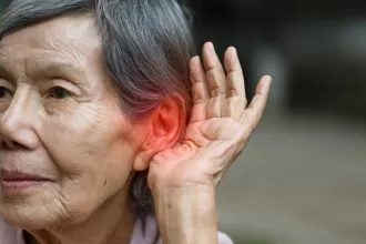 A person receiving an ear piercing, highlighting the procedure and the importance of ear health in relation to hearing loss.
