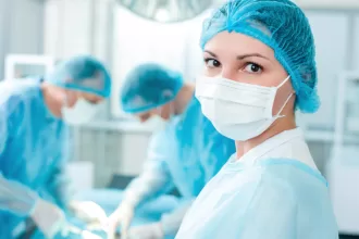 A woman in a surgical gown and mask prepares for thoracic surgery, focusing on lung resection and pleurectomy procedures.