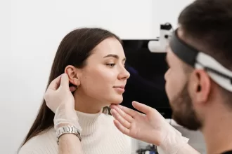 A woman undergoing an ear examination by a doctor, focusing on tympanoplasty for eardrum repair.