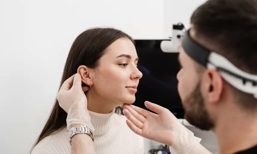A woman undergoing an ear examination by a doctor, focusing on tympanoplasty for eardrum repair.