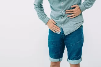 A man resting his hands on his stomach, reflecting on his recent ureteral reimplantation surgery.