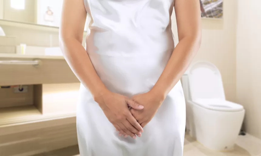 A woman in a white dress stands in a bathroom, symbolizing confidence and renewal after vaginal rejuvenation surgery.