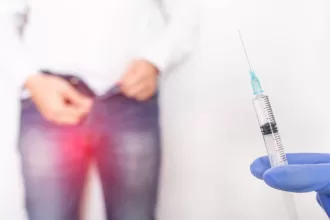 A healthcare professional holds a syringe, preparing for a varicocele repair procedure.